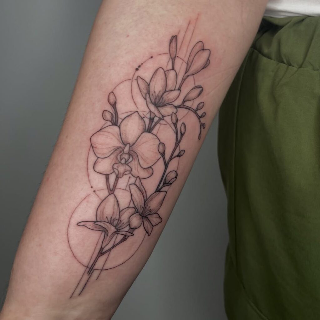 A fine line floral tattoo done by Ruth at No Regrets Bristol. It shows four flowers with fine line circles in the background. 
