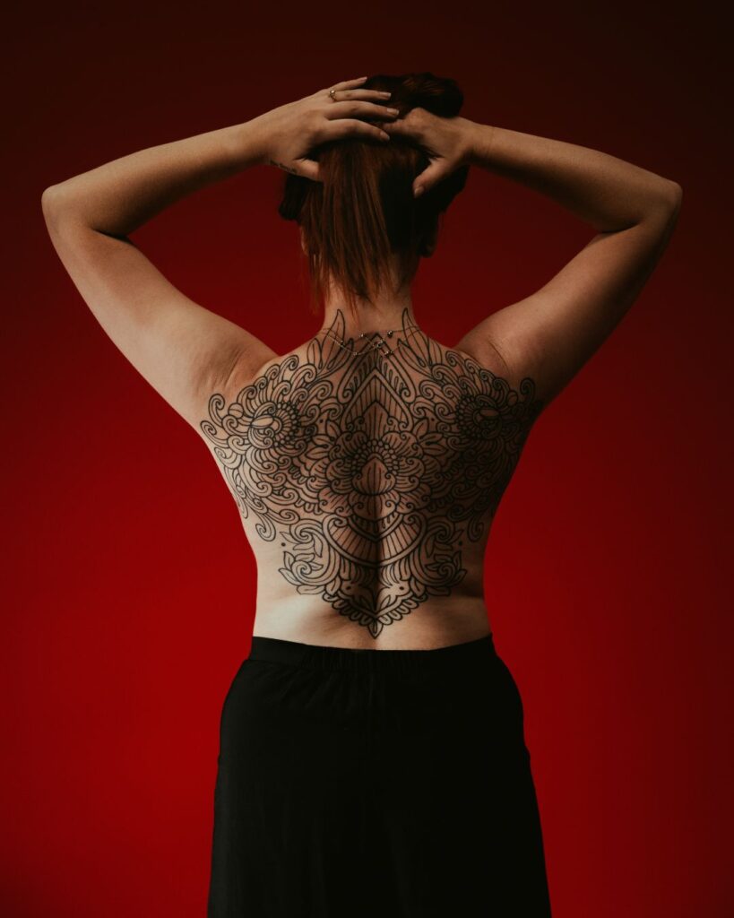 A lady with an ornamental backpiece celebrating past trauma and bringing closure. 