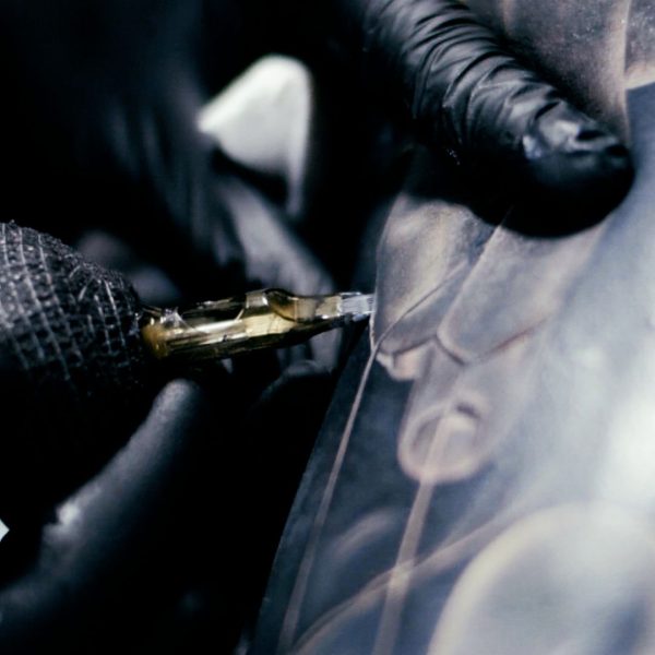 Close up of an artist tattooing a blackwork design.