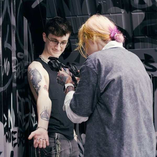 Manchester artist Kristina photographs a clients tattoo on forearm.