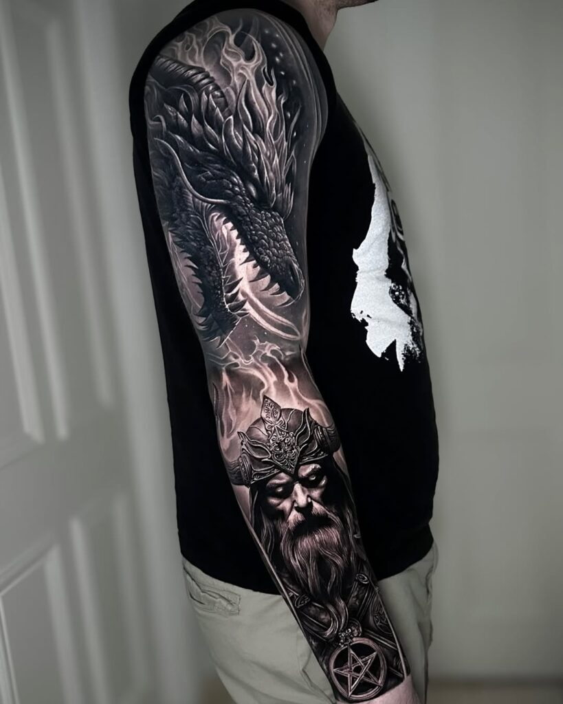 A black and grey sleeve of a dragon breathing fire above a warlock.