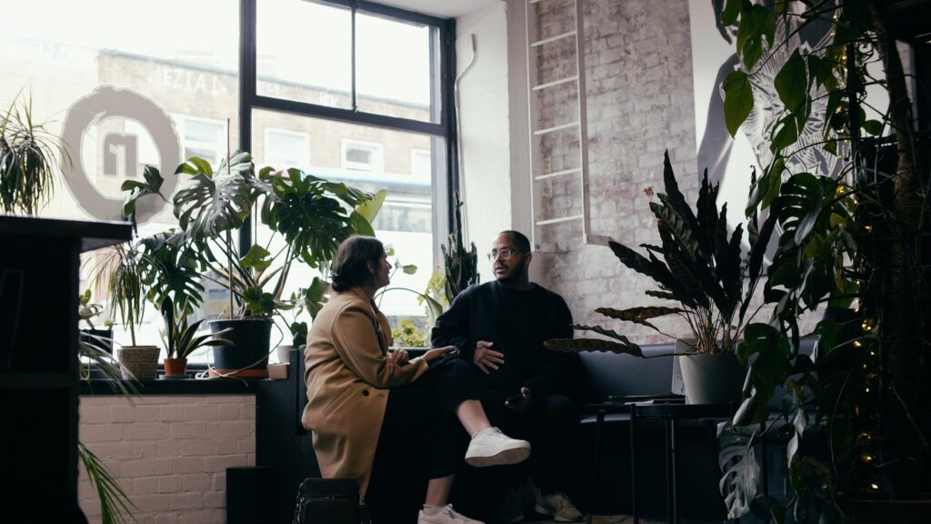 a male tattoo artist sits next to a female client during a tattoo consultation at No Regrets Studios. 