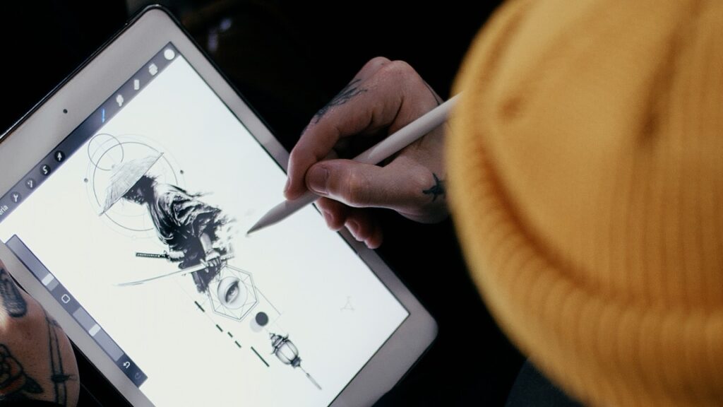 An over-shoulder image of a tattoo artist at No Regrets Miami drawing a tattoo design of a samurai on his iPad.