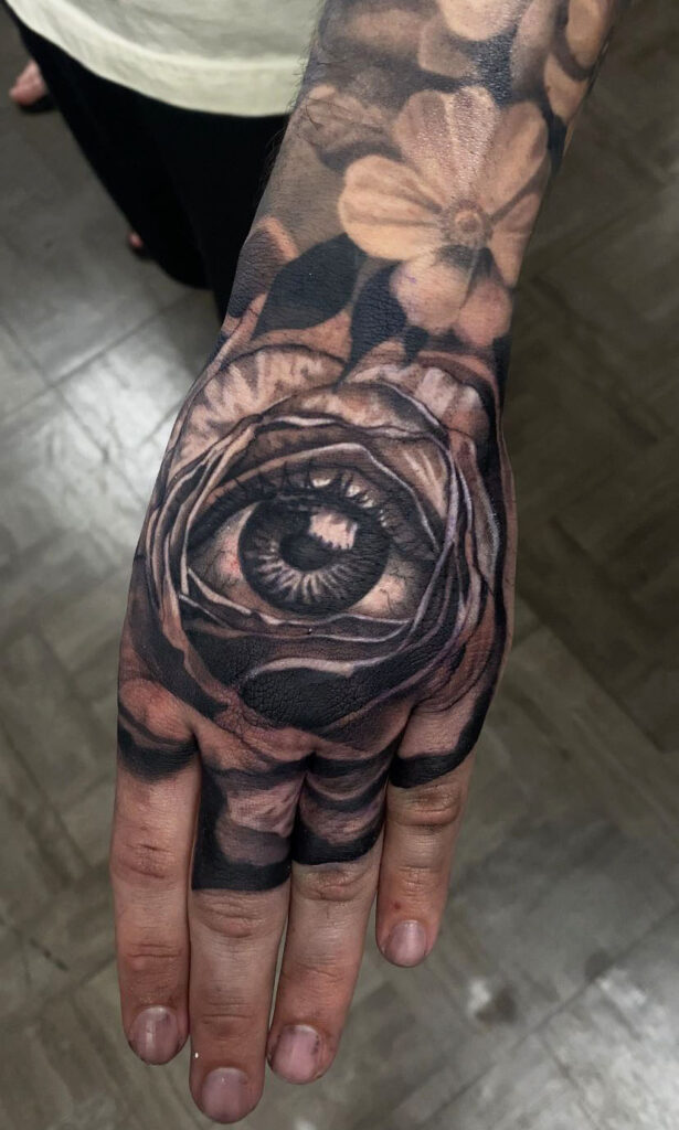 A hand tattoo of a realistic eye by Ruben Jackson.