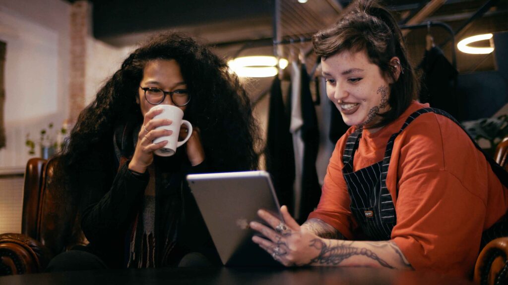 A female tattoo consultant discusses tattoo pricing with a client at No Regrets Studios